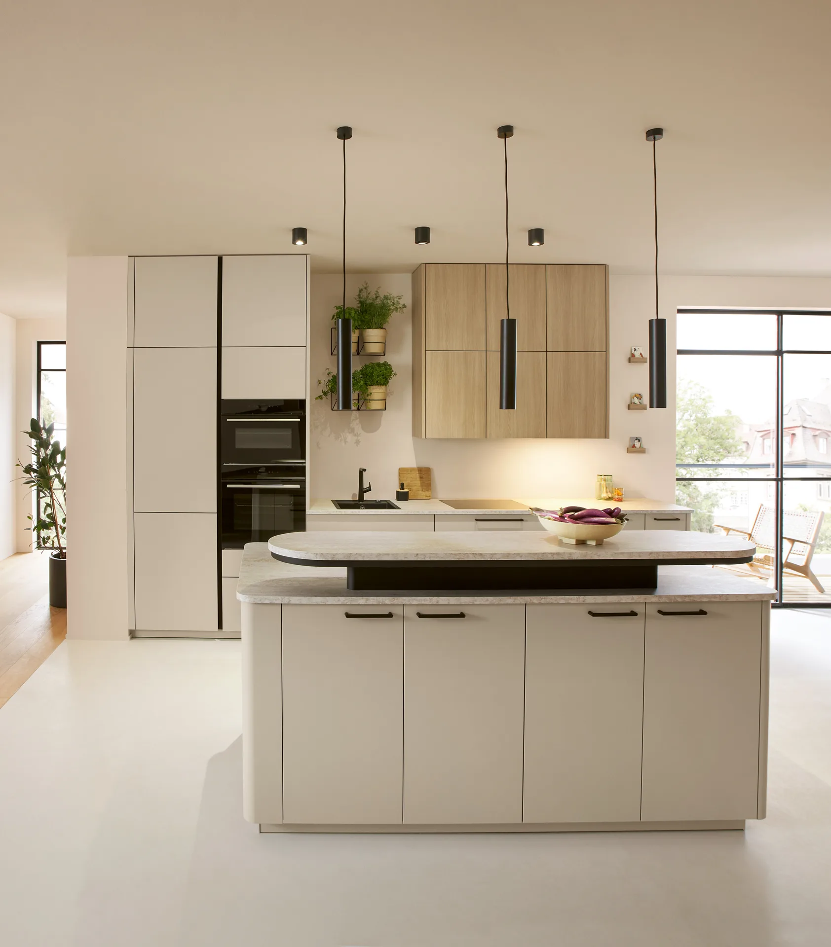 Kücheninsel in Sandbeige mit Eiche-Hängeschränken und schwarzem Backofen — Miller Küchen